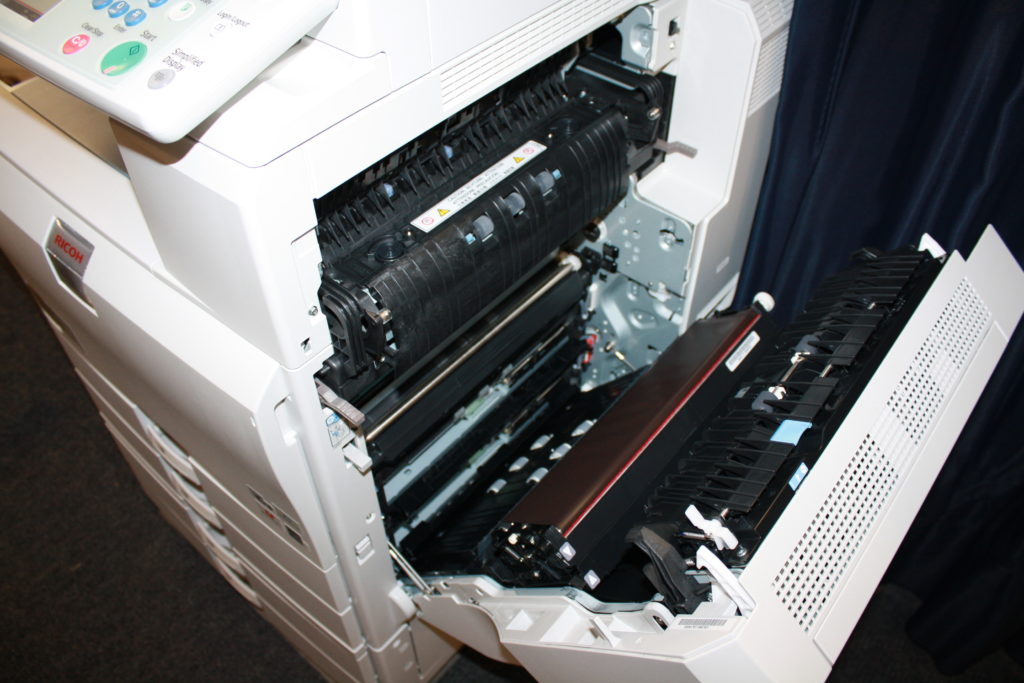 A printer is open and the inside of it.
