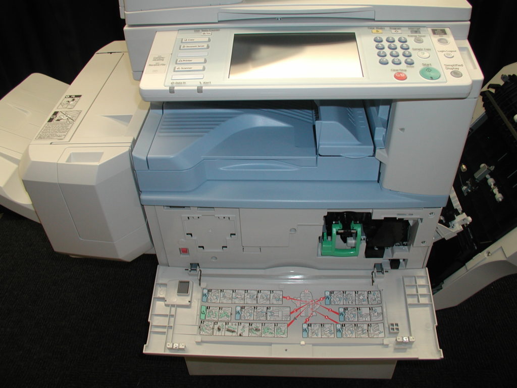 A printer with the keyboard open and a mouse on top.